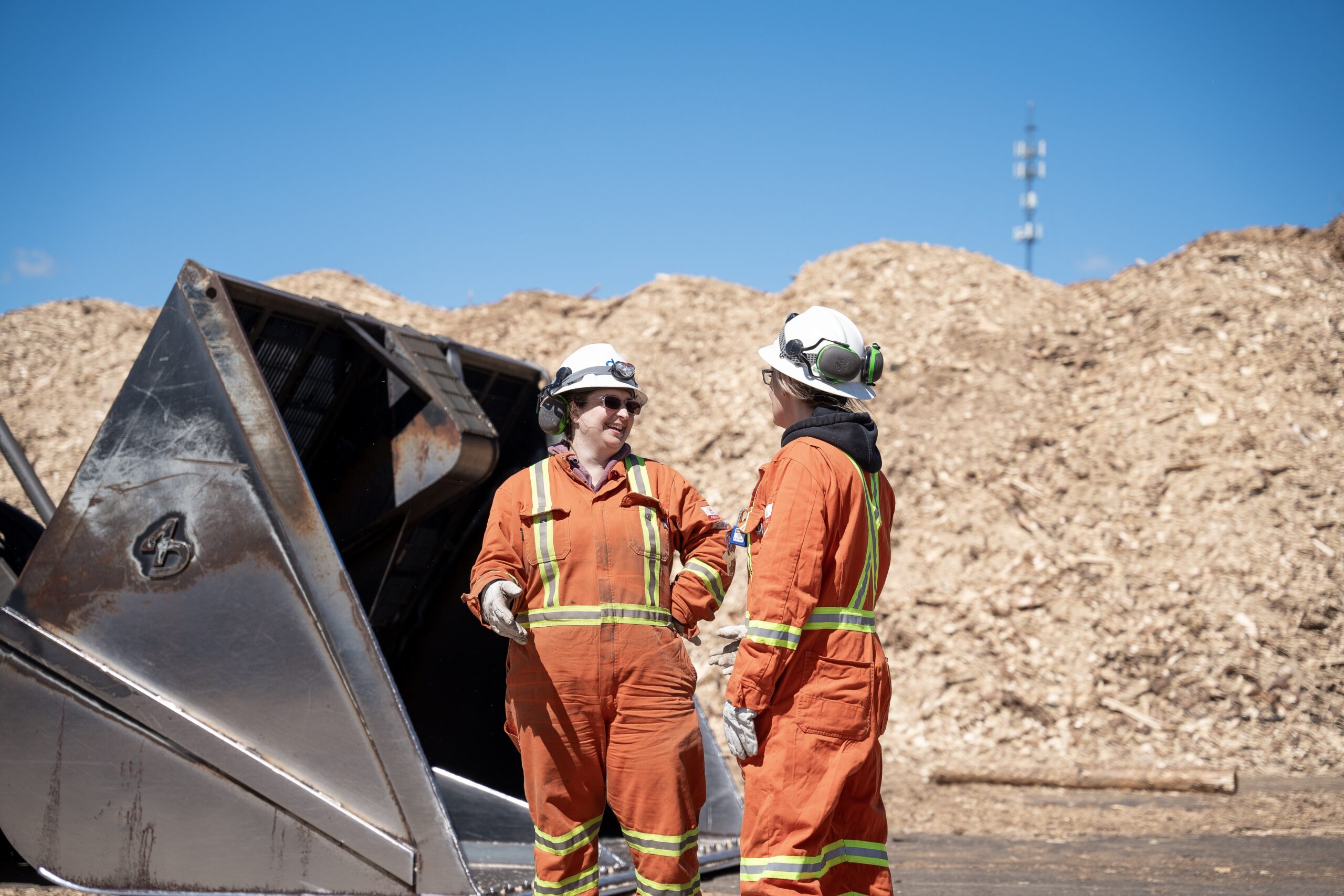 Drax workers in PPE speaking at pellet plant