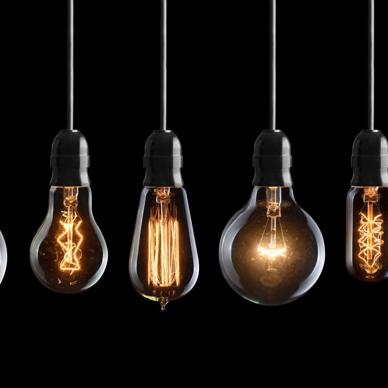 Set of vintage glowing light bulbs on black background