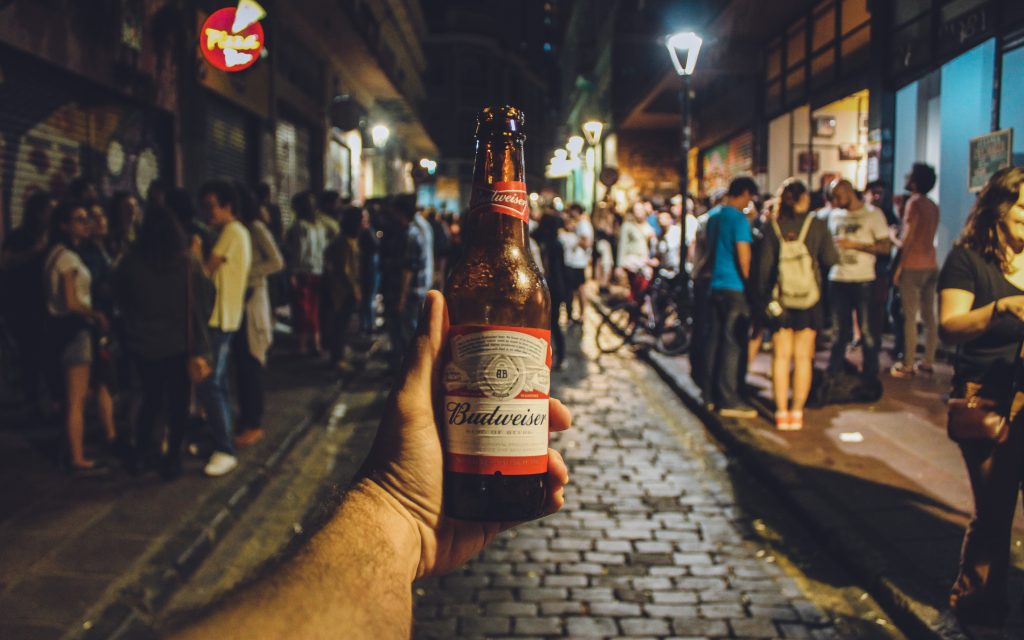 Person holding Budweiser bottle; Photo by Victor Freitas