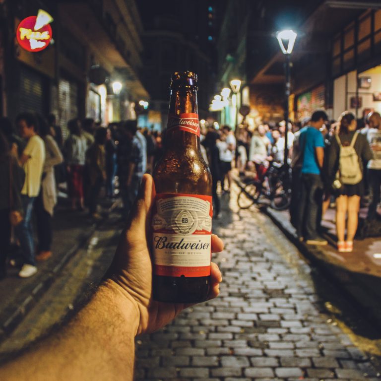 Person holding Budweiser bottle; Photo by Victor Freitas
