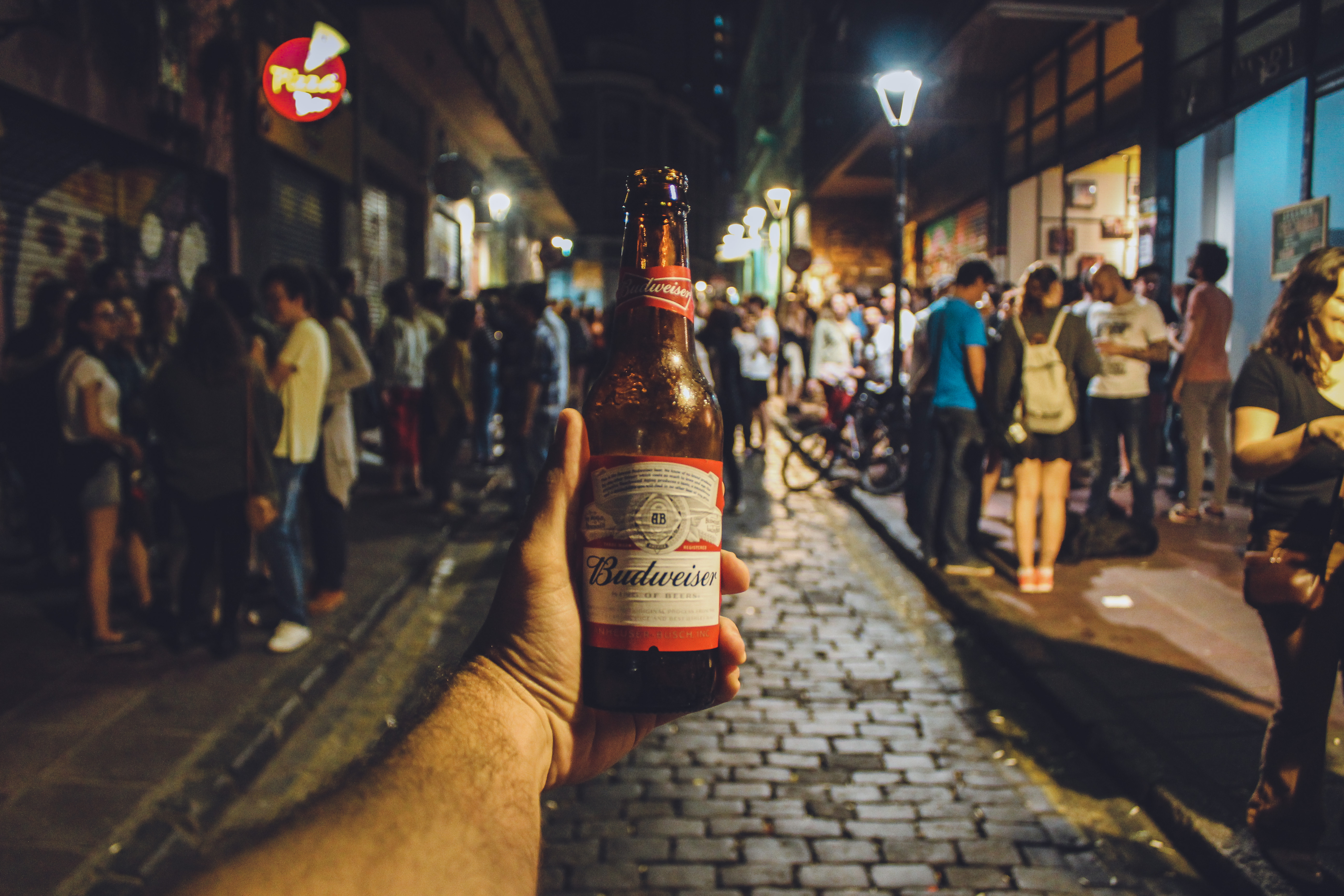Person holding Budweiser bottle; Photo by Victor Freitas