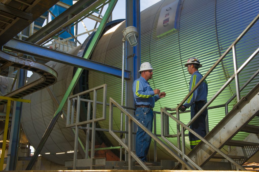 Two workers stand next to machinery at the Morehouse facility in the USA.