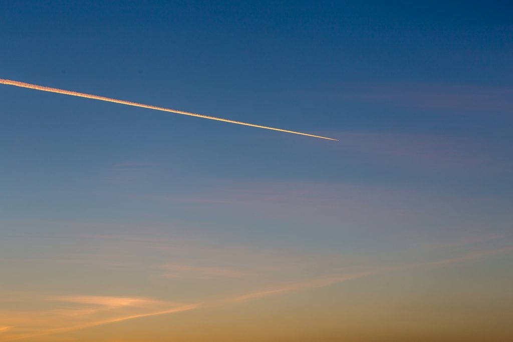 Jet plane leaves contrail in a sunset beautiful sky, copy space for text