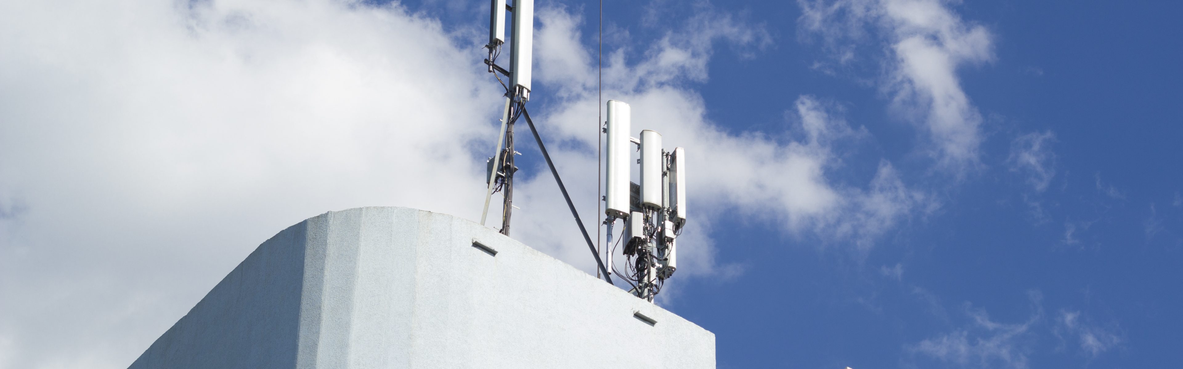 Smart cellular network antenna base station on the telecommunication mast on the roof of a building.
