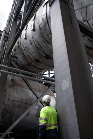 An engineer looks up at flue gas desulphurisation unit (FGD) at Drax Power Station. The massive pipe would transport flue gas from the Drax boilers to the carbon capture and storage (CCS) plant for CO<sub>2</sub> removal of between 90-95%.