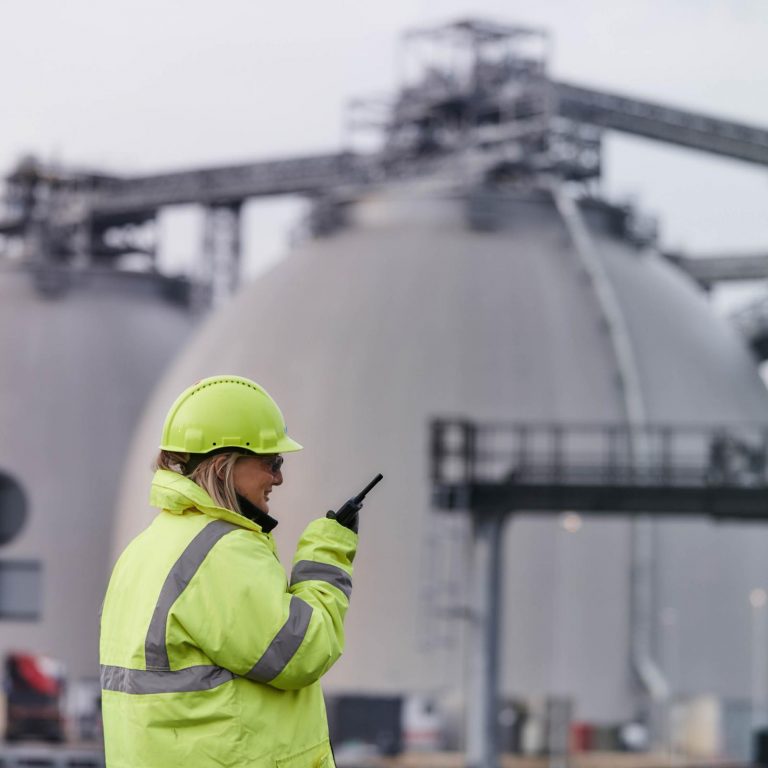 Drax Power Station biomass storage domes with employee in foreground wearing PPE