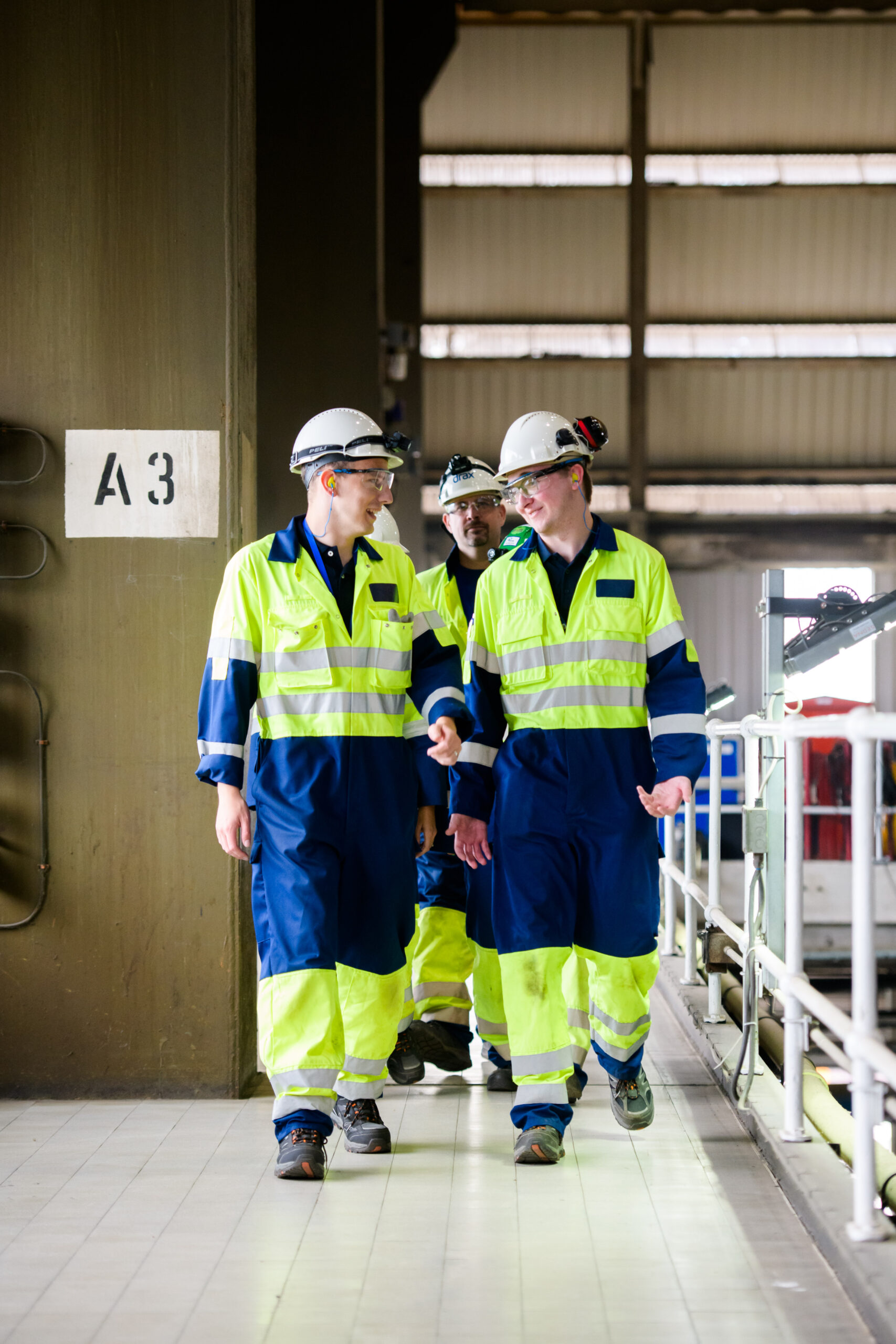 Drax workers in PPE walking in turbine hall