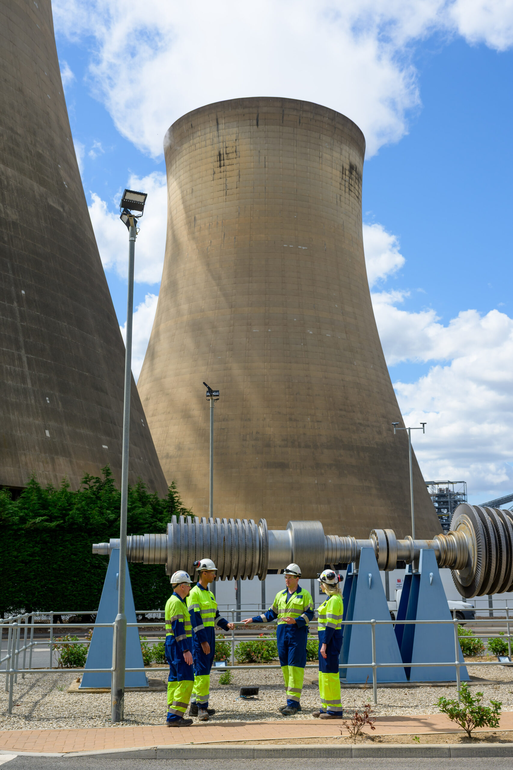 Drax workers in PPE speaking in front of Drax Power Station's cooling towers