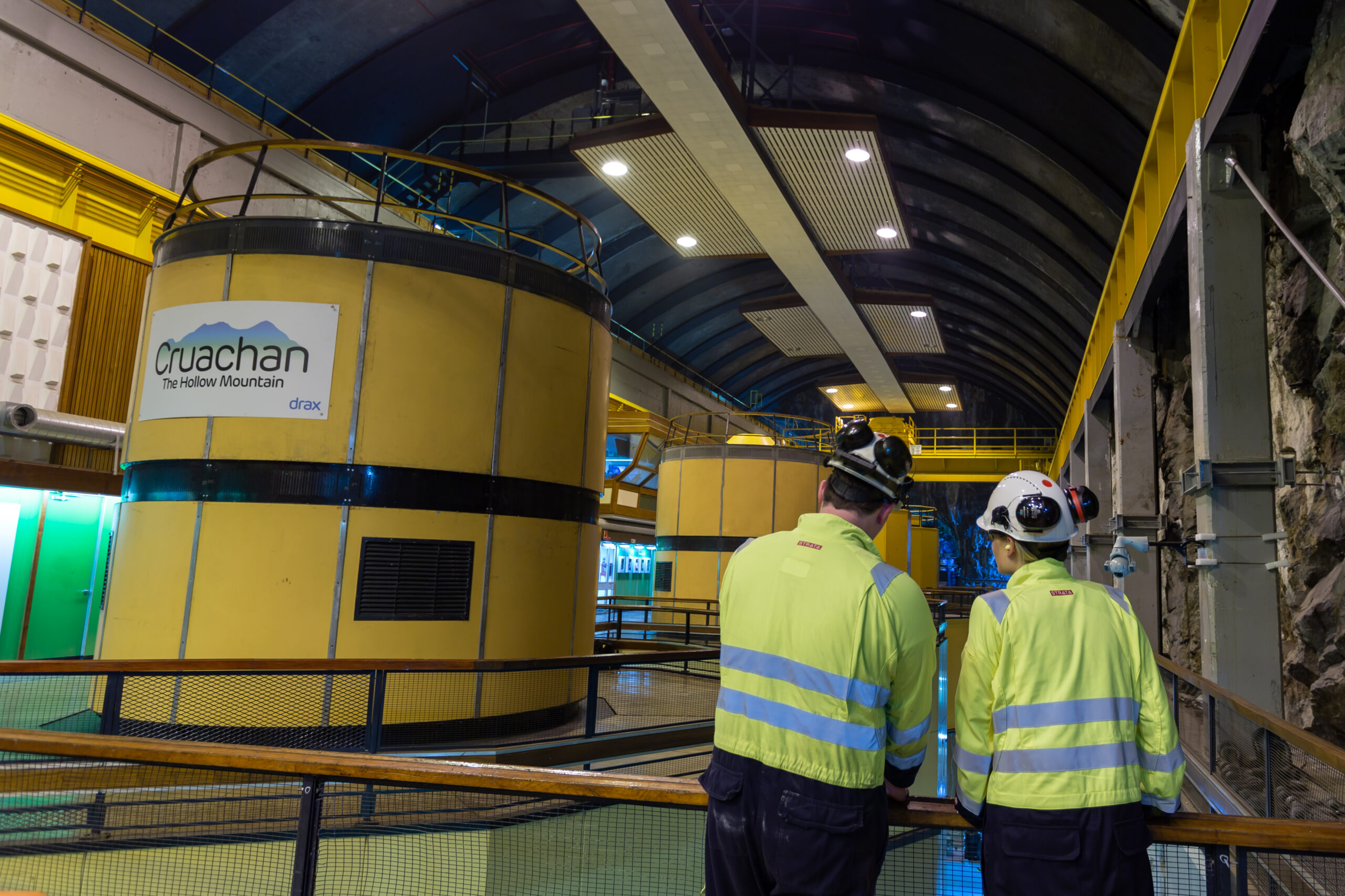 Two Drax workers standing in Cruachan Power Station's turbine hall