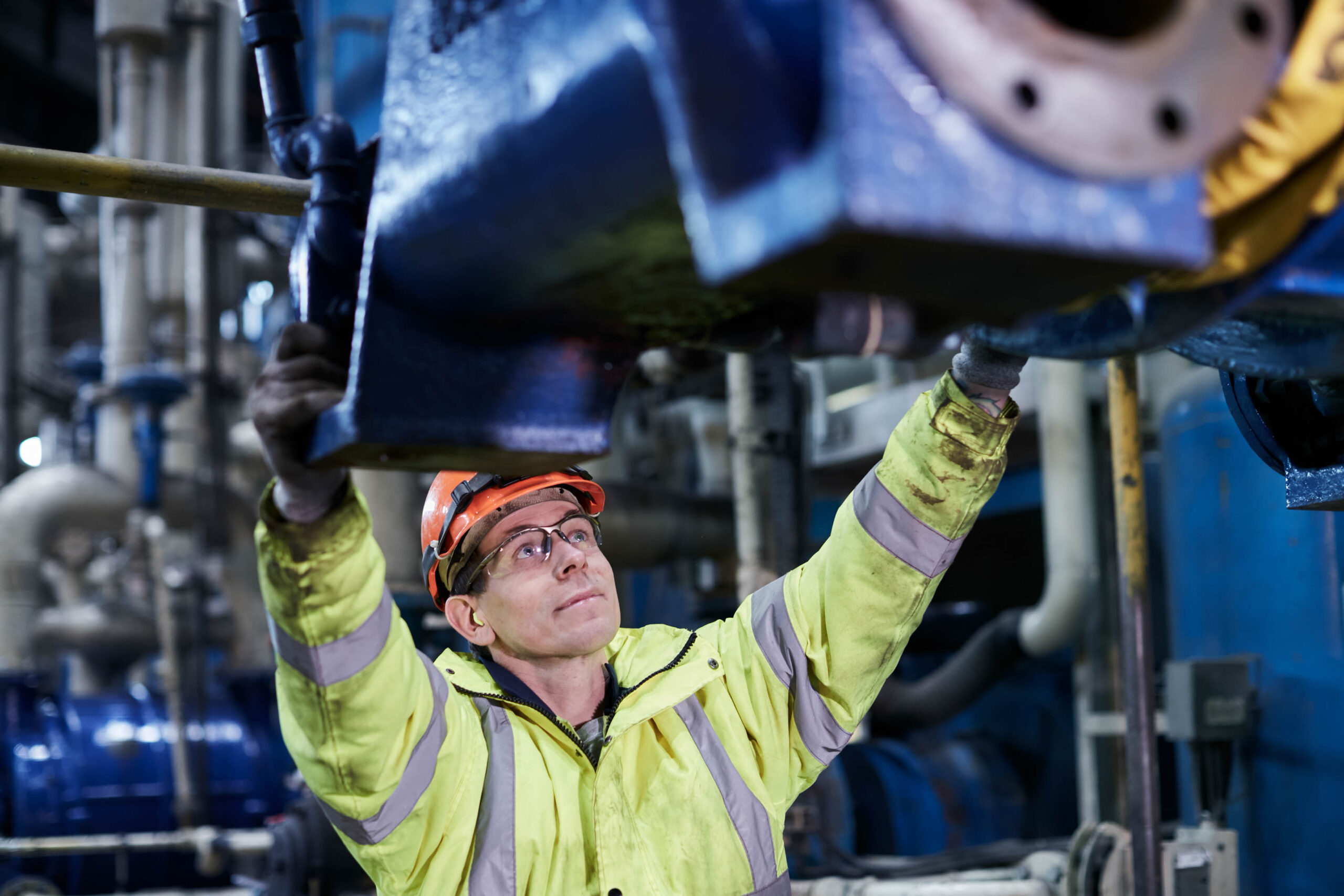 Worker in PPE at Drax Power Station touching a turbine